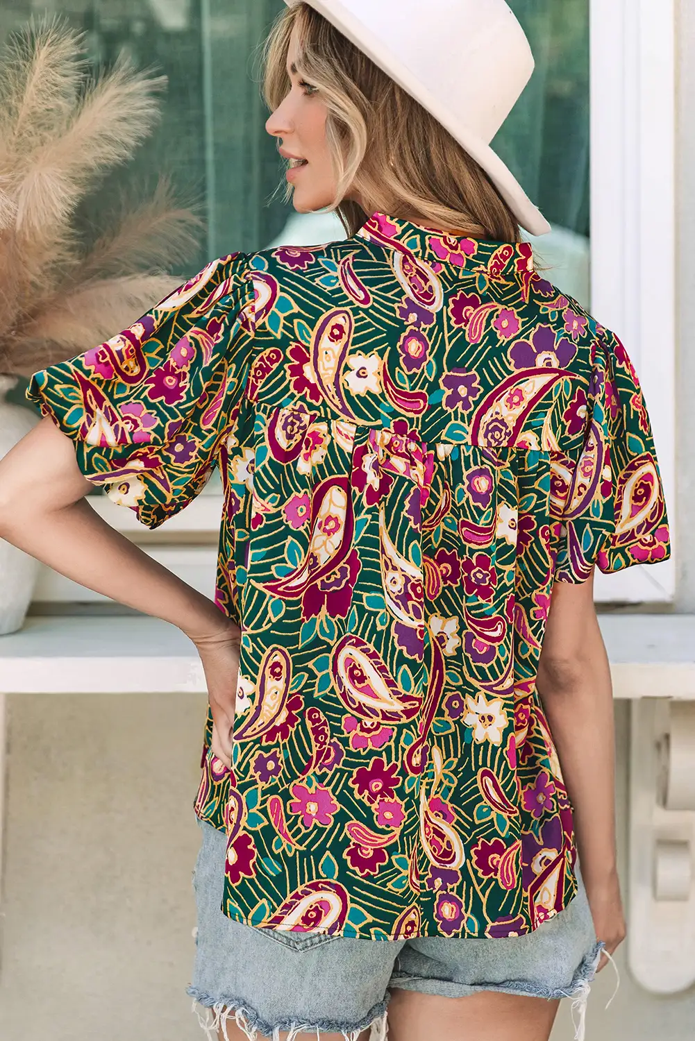 Close view of the green paisley blouse print and V neckline